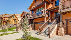 A multi-story residential building with a central staircase, a garage, and a small front yard. - Stunning dog-friendly mountain condo with hot tub, gas grill, & AC (Kamas)