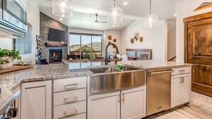 A modern kitchen with granite countertops, stainless steel appliances, and pendant lighting. - Stunning dog-friendly mountain condo with hot tub, gas grill, & AC (Kamas)