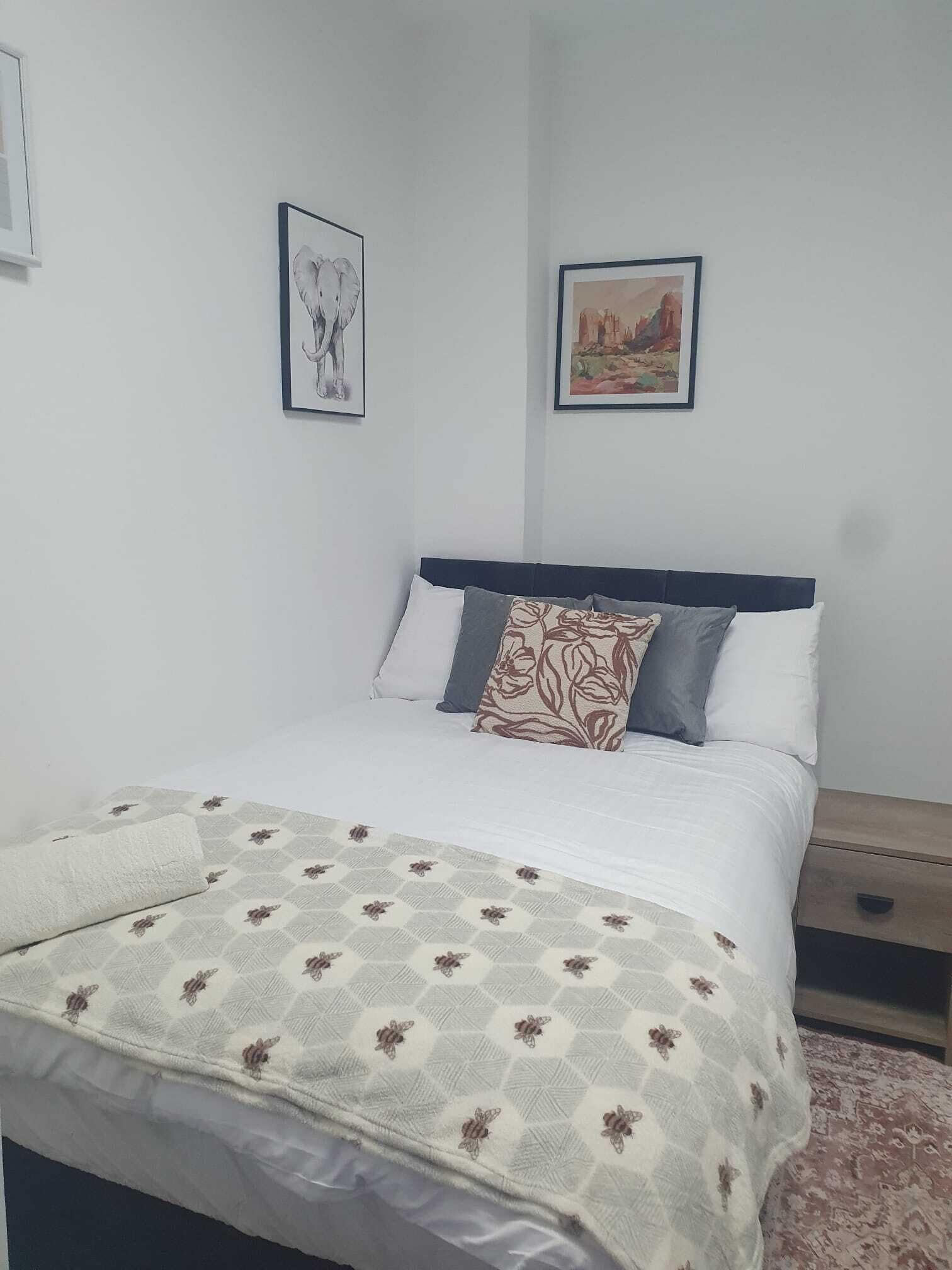 A neatly made bed with a patterned blanket, a headboard, and two pillows.