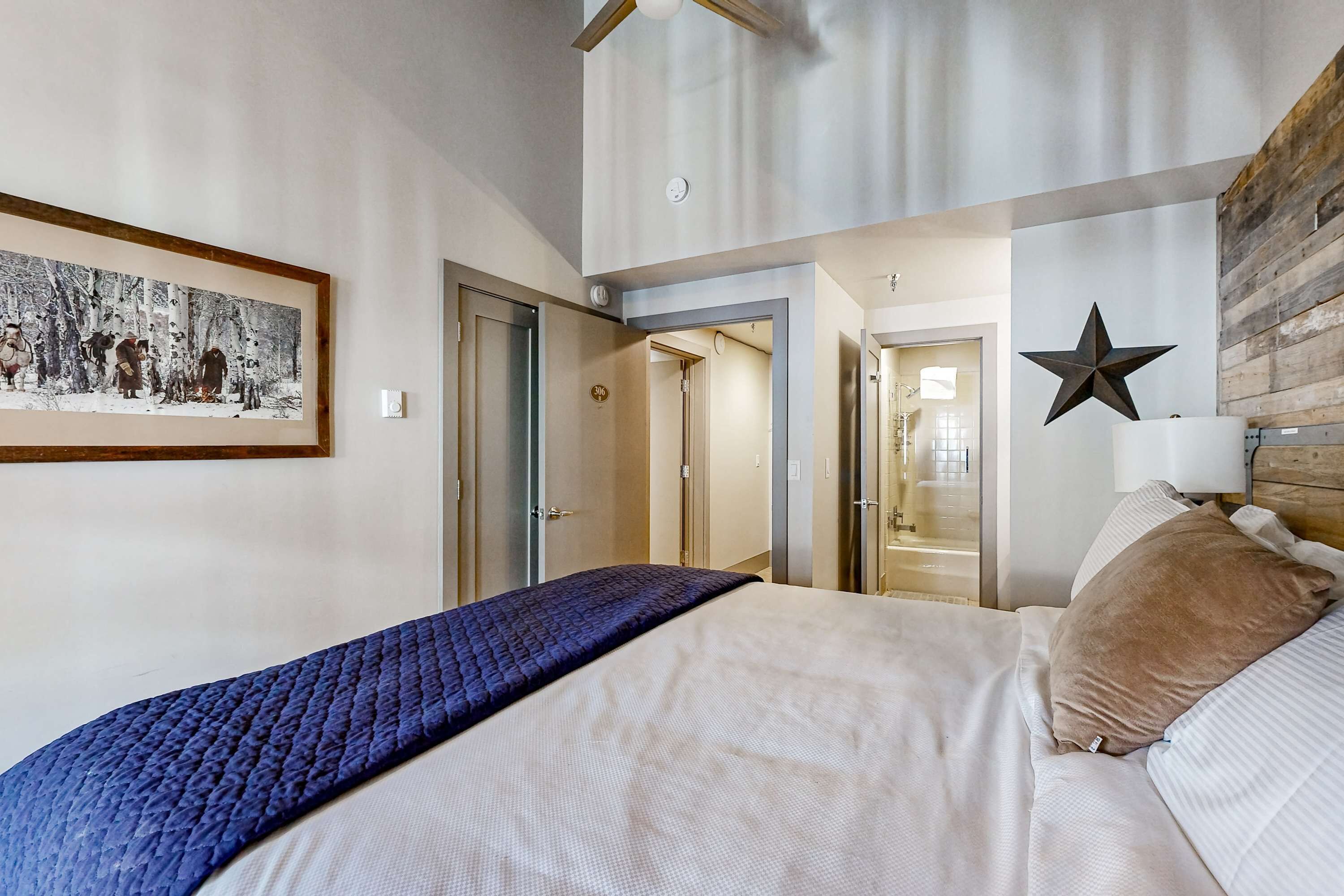 Un dormitorio con una cama, un cuadro enmarco, una decoración de estrella y una pared de madera.