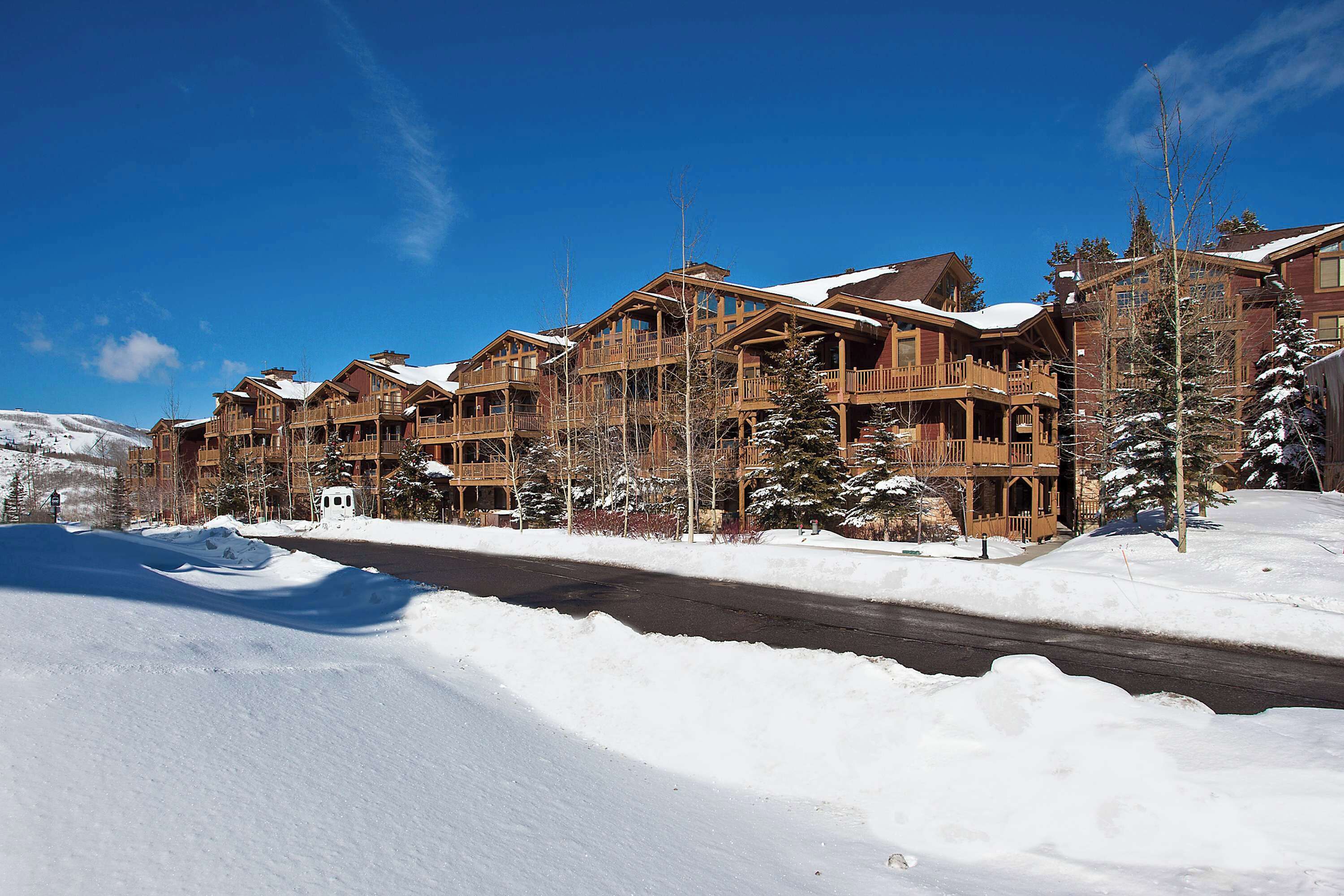 Ein großes Holzhaus mit mehreren Balkonen und einer schneebedeckten Landschaft.