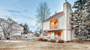 A two-story house with a balcony, a chimney, and a well-maintained lawn. - Modern condo with spectacular views - close to top ski resorts & walk to MARC (Park City)