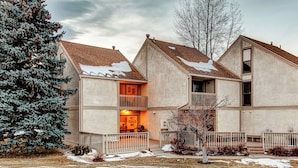 A two-story building with a balcony on the second floor, a covered entrance, and a snow-covered roof. - Modern condo with spectacular views - close to top ski resorts & walk to MARC (Park City)