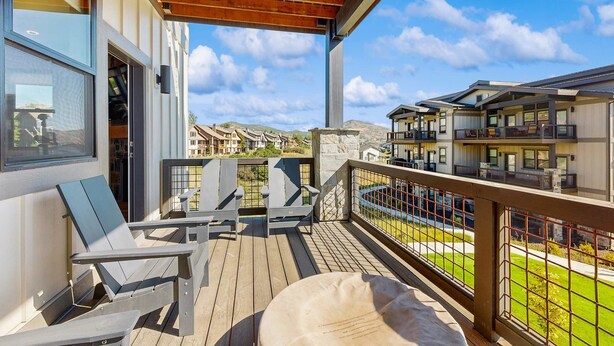 A balcony with outdoor furniture, a pergola, and a view of other buildings. - Lakeview Condo with fireplace, gas grill & W&D - close to skiing, hiking, & lake (Heber City)