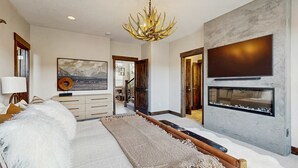 A modern living room with a fireplace, a large TV, and a chandelier. - Three King Suites, 12 min to Deer Valley & Park City Resorts (Kamas)