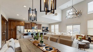 A spacious kitchen with wooden cabinets, a central island, and pendant lighting. - Three King Suites, 12 min to Deer Valley & Park City Resorts (Kamas)