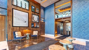 Eine Lobby mit Holzwandverkleidung, Marmorböden und moderner Möblierung.