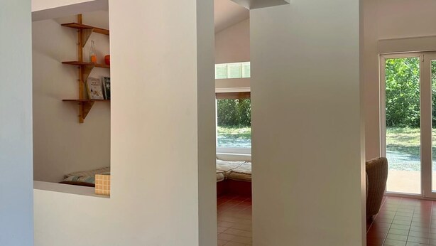 Een modern interieur met een inbouwkast, een bed met uitzicht en een zithoek met uitzicht.