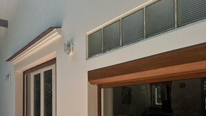 Een gebouw met grote ramen, een overdekte veranda en een lichtgekleurde gevel.