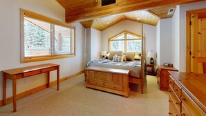 A bedroom with a wooden ceiling, a bed, a desk, and a dresser. - Beautiful ski chalet with gourmet kitchen, theater room & private hot tub (Brighton)