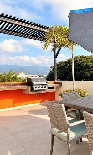 An outdoor patio with a grill, wicker chairs, and a view of mountains. - Rooftop pool + mountain view
Sleeps 6 Family-Friendly Stay in PV (Puerto Vallarta)