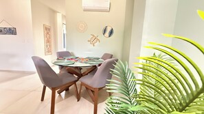 A dining area with a round table, four chairs, and a potted plant. - Rooftop pool + mountain view
Sleeps 6 Family-Friendly Stay in PV (Puerto Vallarta)