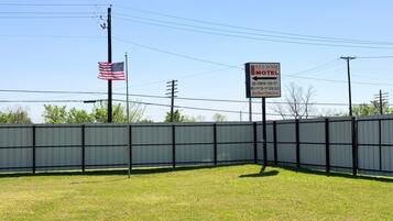 Un área cercada con un letrero del motel Red Door, una bandera estadounidense y postes de electricidad.