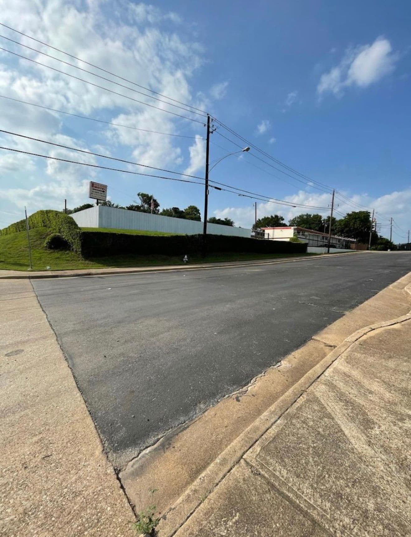 Una carretera con un edificio blanco y un letrero que dice 'ROYAL'.