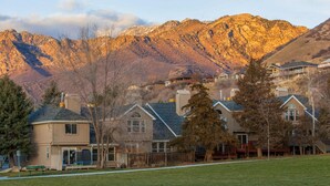 A residential area with houses, a grassy field, and mountains in the background. - Spacious and sophisticated home w/ private hot tub - close to skiing (Cottonwood Heights)
