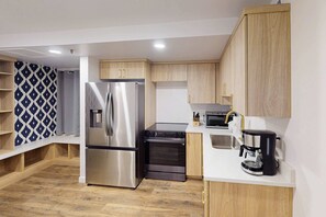 A modern kitchen with a stainless steel refrigerator, a built-in oven, a microwave, and a coffee maker. - Dog-friendly Old Town Empire Condo near resort with  ski storage (Park City)
