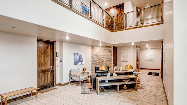 Un amplio salón con chimenea, asientos y vistas al piso superior.
