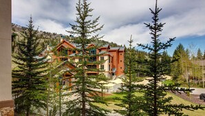 A lodge with multiple buildings, surrounded by trees and a mountainous backdrop. - 2nd-floor ski-in/out condo w/balcony, fireplace, shared pool, hot tub, game room (Solitude)