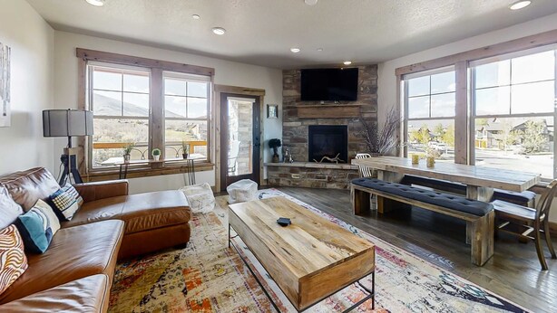 A spacious living room with a fireplace, large windows, a sofa, and a coffee table. - Chic 3BR Mountain Condo Minutes to Deer Valley Gondola & Downtown Park City (Heber City)