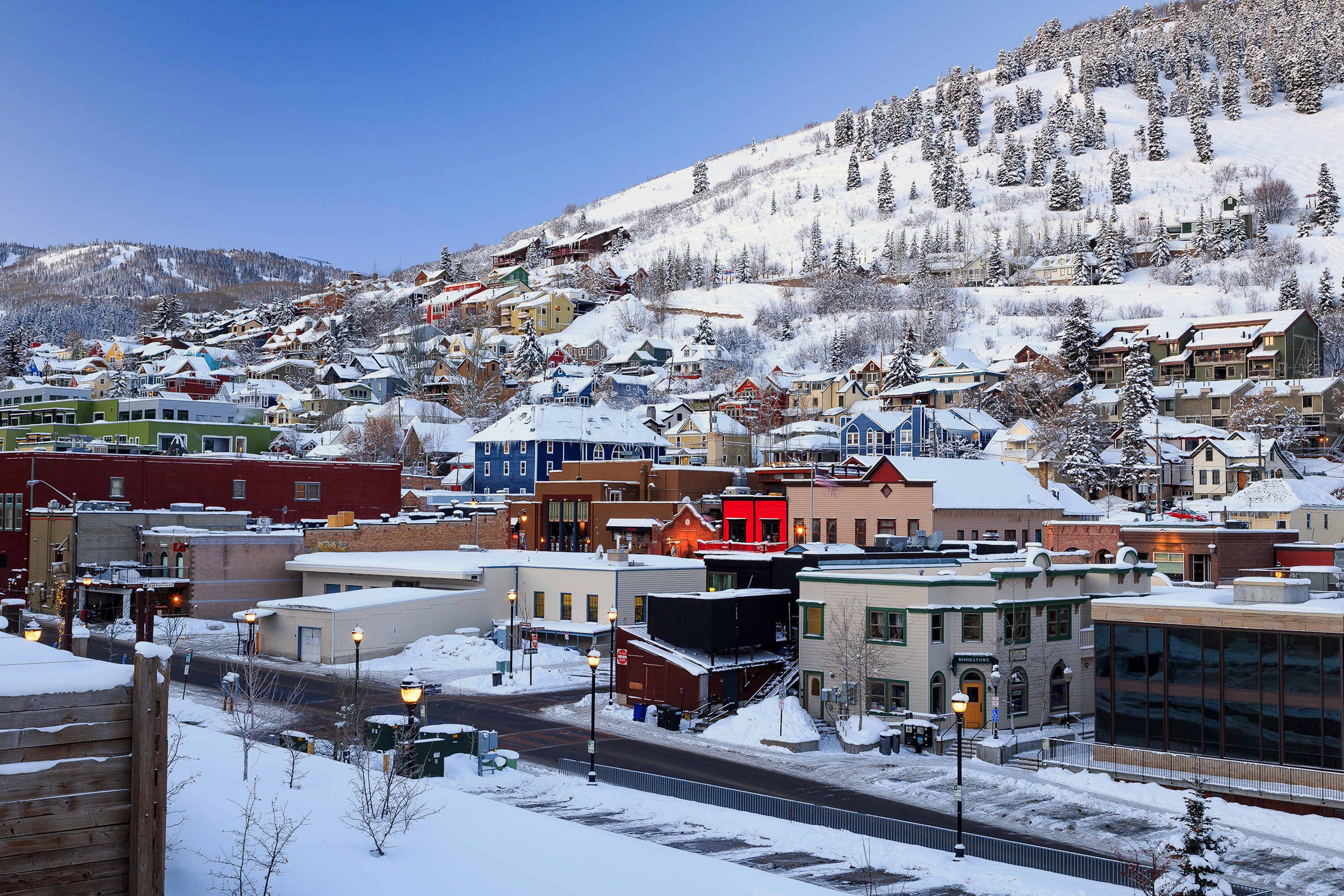 A snow-covered town with buildings and a mountain in the background.