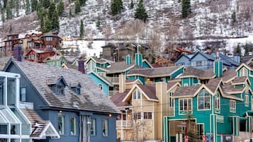 A row of colorful buildings with a mix of architectural styles, including a prominent blue building with a large window and a smaller structure with a sloped roof.