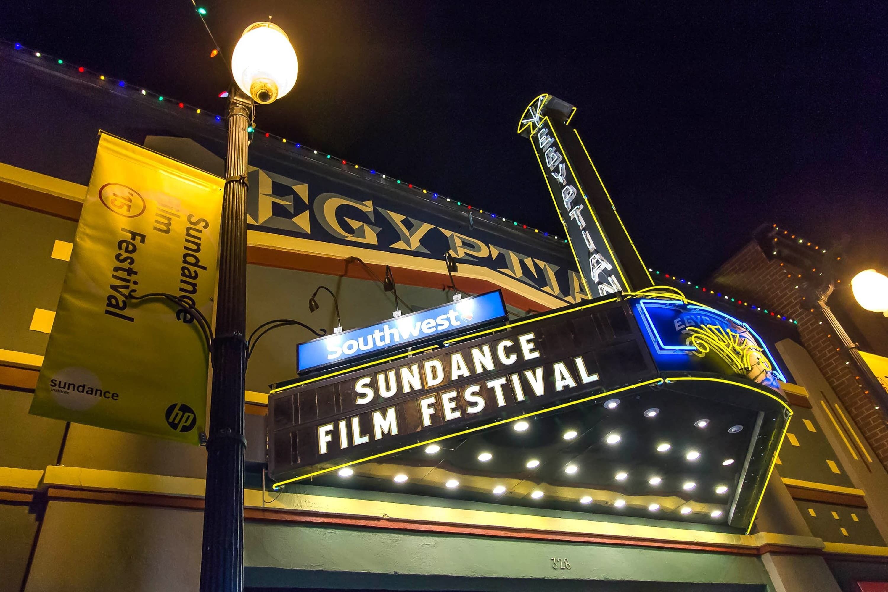 Un cartel con la inscripción 'Sundance Film Festival' y 'SouthWest', una farola y la fachada de un edificio.