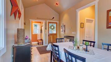 A dining area with a table set for four, a fireplace, and a hallway leading to a door.