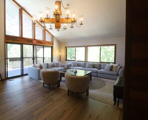 A spacious living room with a large sectional sofa, two armchairs, a coffee table, and a chandelier. - Alpine Gem - Pools, Hot Tubs, Tennis - Walk 5 Mins to Lift & 8 Mins to Dining (Park City)