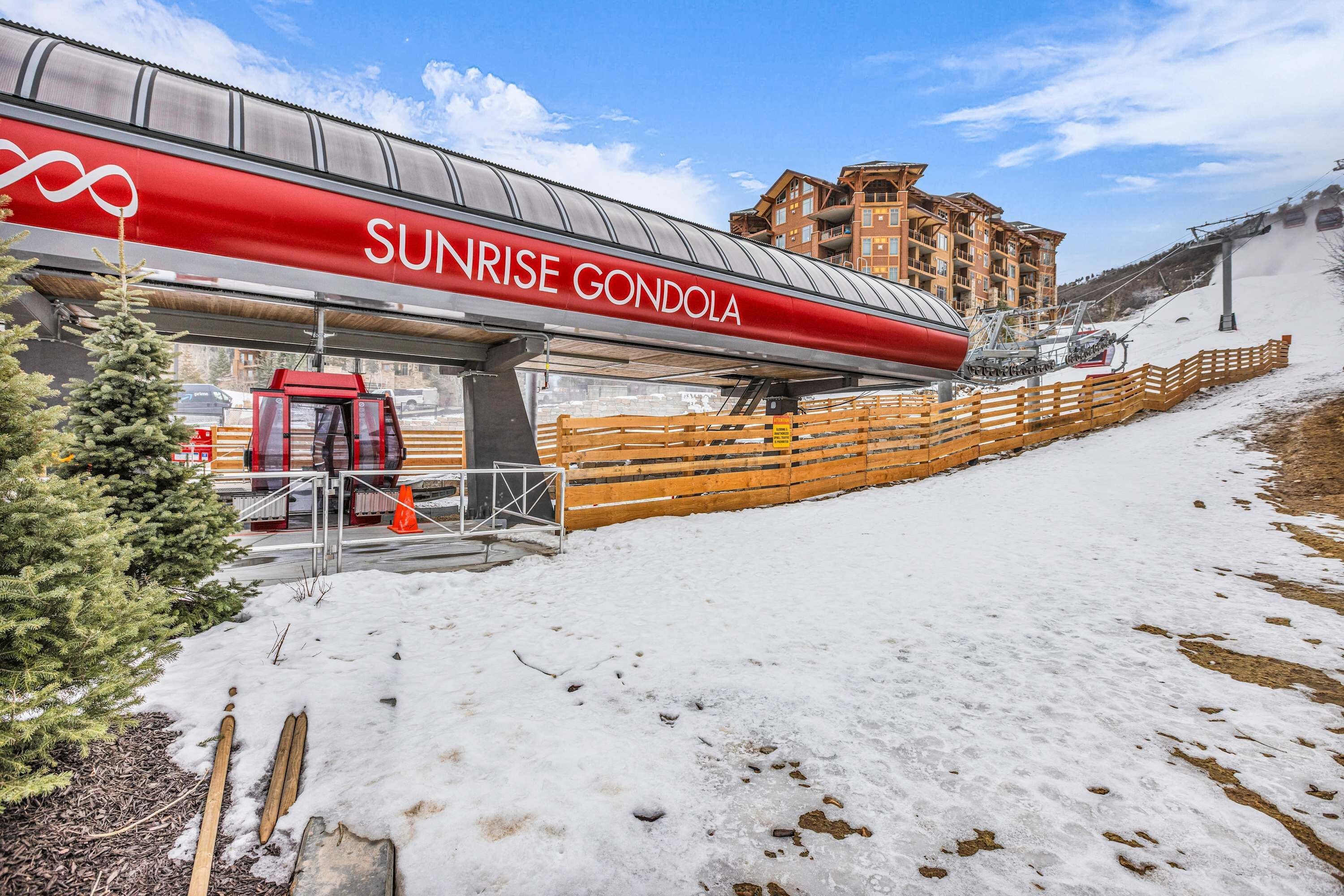 Ein Skigebäude mit roter und weißer Fassade, Seilbahnen und verschneitem Gelände.
