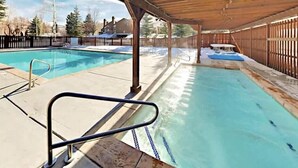 A swimming pool with a wooden deck and a covered area. - Remodeled mountainside home with outdoor heated pool & hot tub - walk everywhere (Park City)