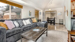 Ein Wohnzimmer mit Ecksofa, Couchtisch und Essbereich mit Tisch und Stühlen.