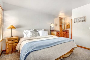Ein Schlafzimmer mit einem Bett, Nachttischen, einem Schminktisch und einem Spiegel.