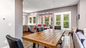 Un comedor con mesa de madera, sillas y sofá.