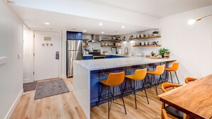 A modern kitchen with a central island, bar stools, and a dining table. - Beautifully Updated Luxury Condo -Hot Tub - Walk to Town Lift (Park City)
