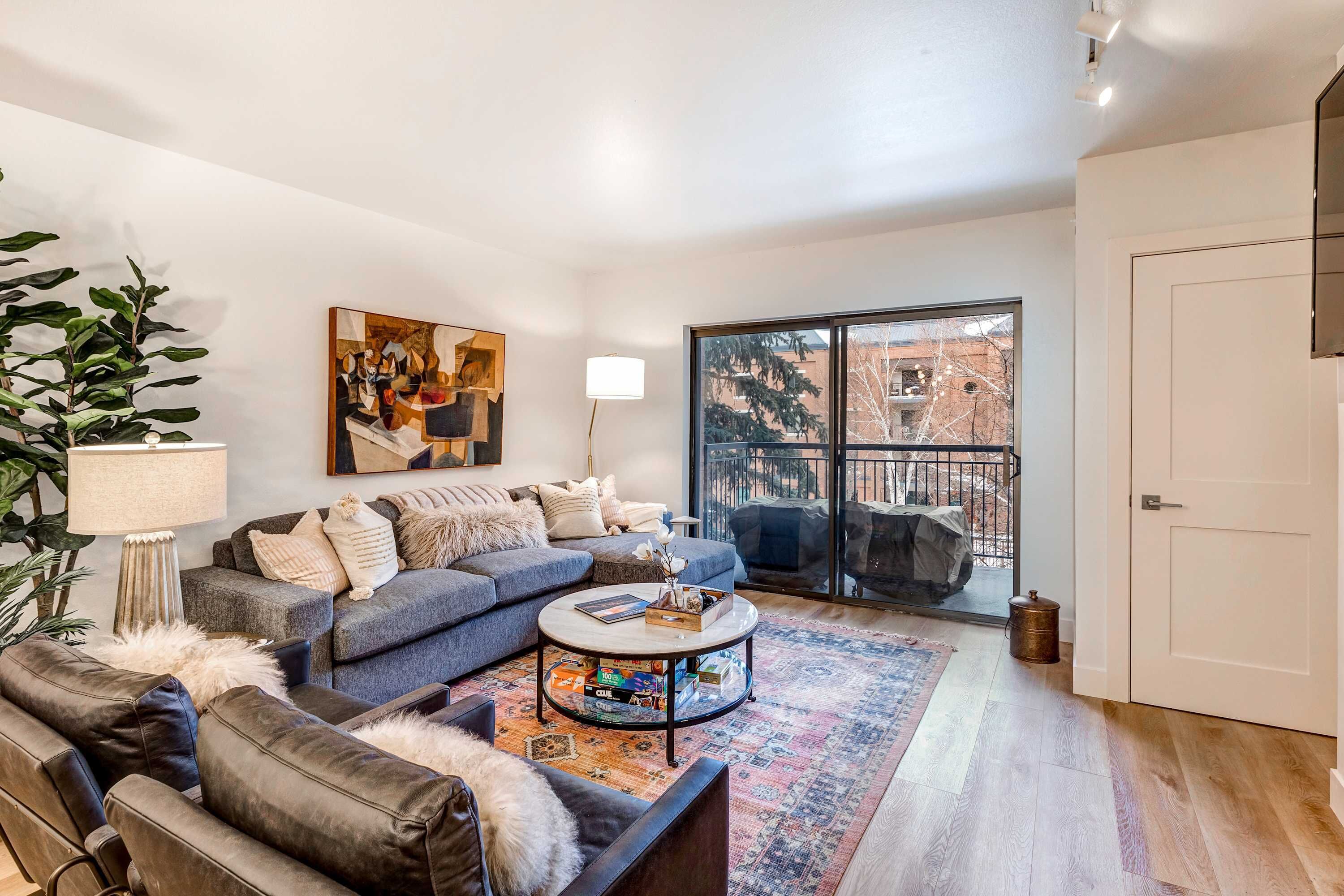 A modern living room with a sofa, coffee table, and a large window with a view.