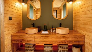 A wooden bathroom with two sinks, a mirror, and a towel rack. - Mimark Serengeti Luxury Camp (Serengeti)