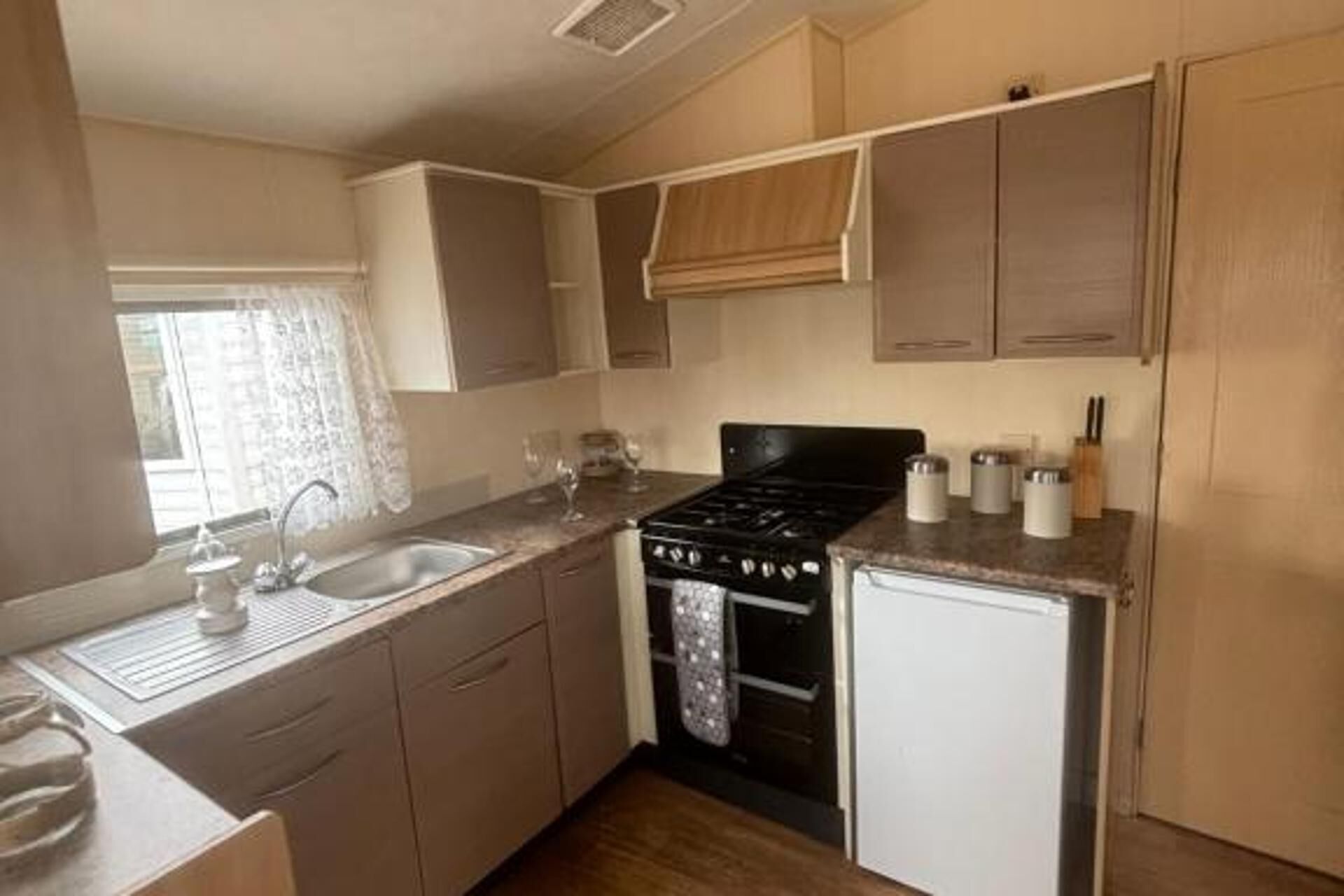 A compact kitchen with a stove, sink, and cabinets.