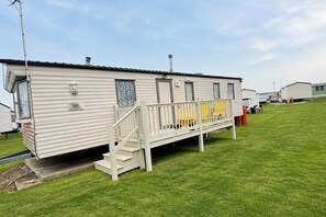 A mobile home with a porch and a small staircase. - Seaside Tranquility Retreat in Clacton (Clacton-on-Sea)