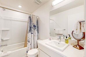 Ein modernes Badezimmer mit Badewanne, Toilette und Waschbecken.