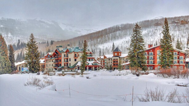 A snow-covered lodge with multiple buildings, a ski slope in the background, and a mountainous landscape. - Mountainview Condo with Ski-In/Out Access, Club Solitude Access with Pool & Hot Tub (Solitude)