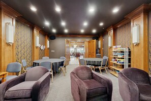 A conference room with tables and chairs, wooden walls, and a bookshelf. - Mountainview Condo with Ski-In/Out Access, Club Solitude Access with Pool & Hot Tub (Solitude)