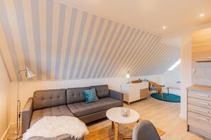 Un salon moderne avec un canapé, une table basse ronde et un coin repas comprenant une chaise et une table.