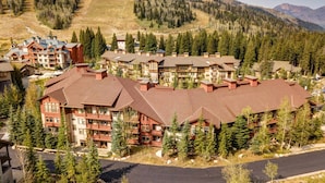 Eine Lodge mit mehreren Gebäuden, umgeben von Bäumen und Bergen.