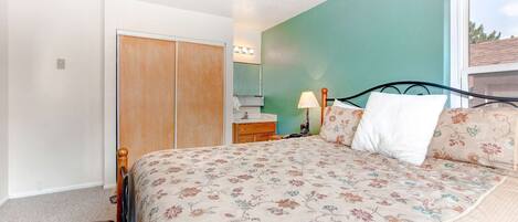 Un dormitorio con cama, cómoda, espejo y ventana.