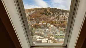 A view through a window of a town with buildings and a hill in the background. - Quintessential Historic Old Town-Full Kitchen-Mountain Views (Park City)