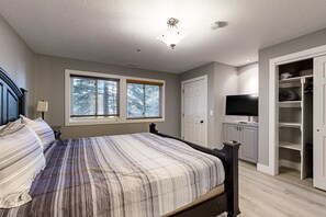 A bedroom with a bed, a TV, a wardrobe, and a window. - Old Town renovated first-floor condo with shared all-season pool, walk to slopes (Park City)