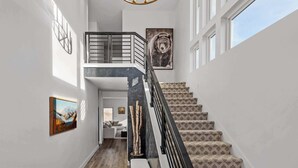 A staircase with patterned carpet, a black railing, and a bear artwork on the wall. - Panoramic views, hot tub & game room, Minutes from Jordanelle Express Gondola (Heber City)