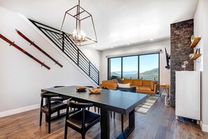 A modern interior with a dining area, staircase, and a view of the outdoors. - Stunning Views, Family Fun & Steps from Deer Valley's New East Village (Hideout)