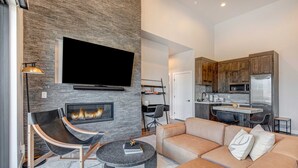 Ein modernes Wohnzimmer mit Kamin, Flachbildfernseher und einer Couch.
