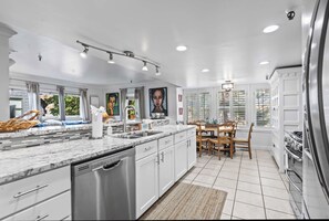 A modern kitchen with white cabinetry, a marble countertop, and a built-in dishwasher. - Stylish condo in prime location just steps from Main Street & Town Lift Plaza (Park City)
